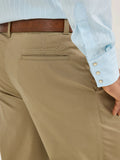 Wrangler Men's Wrangler Casuals® Pleated Front Relaxed Fit Pants in khaki, showcasing back pocket detail and blue shirt.