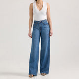 Model wearing Wrangler High Rise Wide Leg Jeans with a white tank top and stylish shoes, showcasing contemporary western fashion.