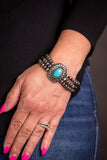 West & Co 3 Strand Faux Navajo Pearl Stretch Bracelet with Turquoise Flower Concho, worn on a woman's wrist.