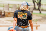 Woman wearing Red Dirt Hat Co Bass Lightning T-Shirt with graphic design outdoors.