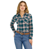 Women in a green plaid flannel shirt, showcasing Western style with snap buttons and two front pockets.