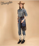Model wearing Wrangler leather fringe jean pocket crossbody bag and cowboy boots in western style.