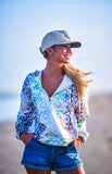 Hooey Ladies Mazatlan Pullover Hoody HH2607AZCR worn by a woman on the beach with a cap and denim shorts.