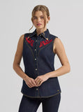 Model wearing a Wrangler Lainey Wilson X embroidered sleeveless denim shirt featuring flame designs.