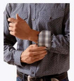 Man adjusting cuff of Ariat Men's Wrinkle Free Dennis Fitted Long Sleeve Snap Shirt with plaid detail.