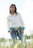 Cruel Girl women's floral embroidered cream long sleeve snap shirt styled with turquoise belt in a grassy field.