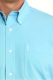 Cinch Men's sky blue long sleeve shirt close-up featuring white button front and logo on pocket.