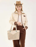 Montana West woman wearing a tan PU leather tote bag with floral design and western style.