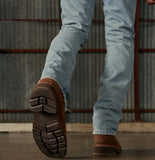 Close-up of Tecovas LongHaul work boot sole on a person walking in jeans.