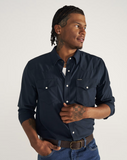 Man wearing TECOVAS Men's Performance Western Pearl Snap Long Sleeve Shirt in Navy, featuring twin front pockets.