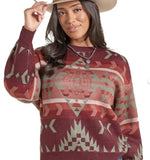 Panhandle Slim Women's Aztec Sweater with bold patterns, worn by a model smiling and styled with a hat