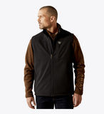 A man wearing an Ariat Men's Vernon Softshell Vest, showcasing its stylish design and practical features.