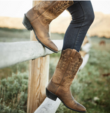 Ariat Women's Heritage R Toe Western Boot showcased with a rustic fence, emphasizing classic Western style and comfort.