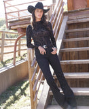 Cruel Denim women's black long sleeve burnout top styled with western accessories outdoors.