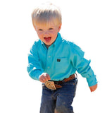 Cinch Infant Boy's Solid Turquoise Long Sleeve Button Down Shirt worn by a young boy playing outside.