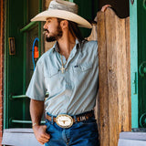 Man in cowboy hat and light blue shirt wearing Montana Silversmiths Southwest Sun Large Buckle with Longhorn.