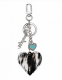 Wrangler cowhide heart bag charm in black with turquoise enamel heart and vintage filigree details.