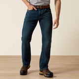 Ariat Rebar M4 Relaxed DuraStretch Edge Boot Cut Jean worn by a man in work boots, showcasing durability and comfort.