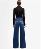 Woman wearing 7 For All Mankind ultra high rise wide leg jeans, showcasing a stylish back view with wide legs.