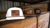 Hooey Liberty Roper hats in white, brown, and black with leather flag patches displayed on a wooden surface.