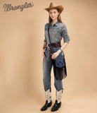 Model wearing Wrangler leather fringe crossbody bag styled with denim shirt and cowboy boots