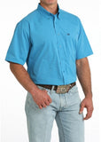 Cinch Men's Arenaflex bright blue short sleeve performance western shirt worn with jeans and a belt.