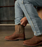 Man wearing Tecovas LongHaul waterproof square toe work boots while adjusting jeans.