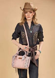 Model wearing a Wrangler Women's Braided Paisley Bandana Tote Bag in Pink with cowboy hat and western outfit.