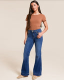 Model wearing 7 for all mankind Medium Melrose Dojo 30" denim jeans with a brown top and stylish shoes.