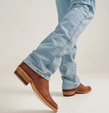 Tecovas The Cartwright men's cowboy boot with brown leather, paired with light blue jeans, demonstrating western style.