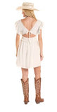 Back view of a woman wearing a Rock & Roll Denim embroidered mini dress with cowboy boots and a hat.