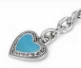 Close-up of a Wrangler horseshoe bag charm featuring a turquoise heart with decorative silver detailing.
