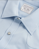 Tecovas Men's Performance Western short sleeve shirt detail in sky blue, showcasing label and button design.