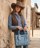 Woman wearing Wrangler Women's Paisley Print Tote Crossbody Bag in a western setting.