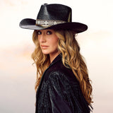 Charlie 1 Horse x Lainey Wilson Wildflower straw hat on a woman with long hair and a fringed jacket.